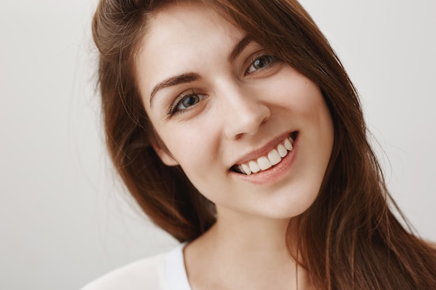 Close-up of beautiful young woman looking happy, smiling with white teeth