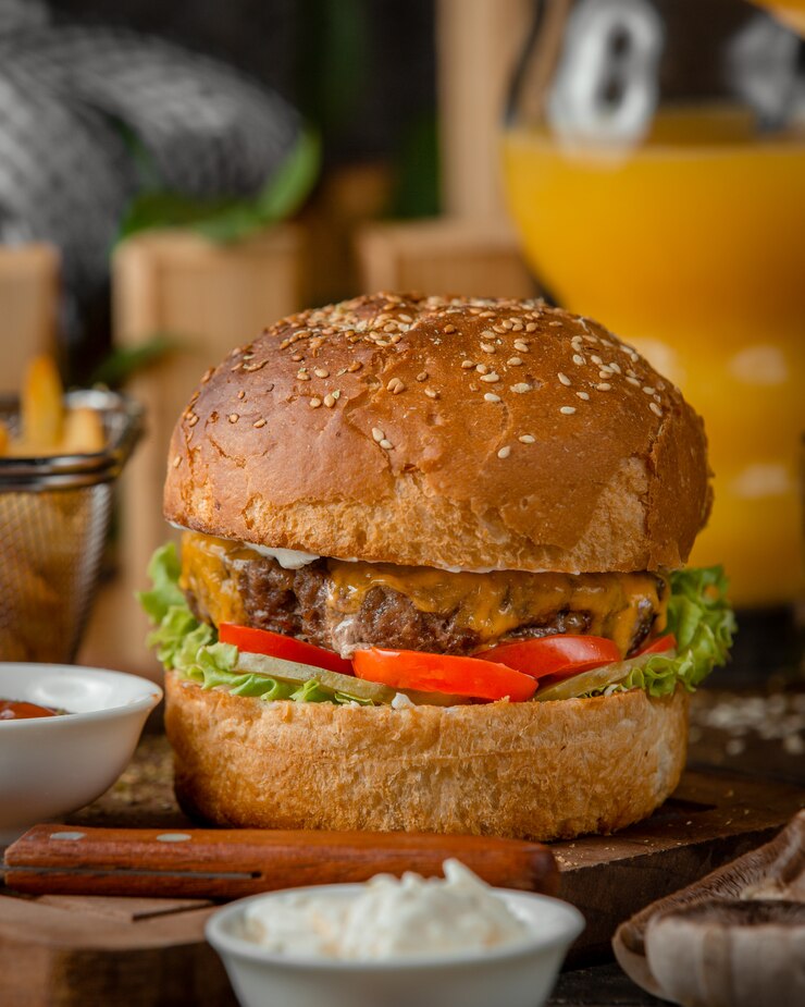 Free Photo close up of beef burger with melted cheddar, tomato, lettuce and mayo