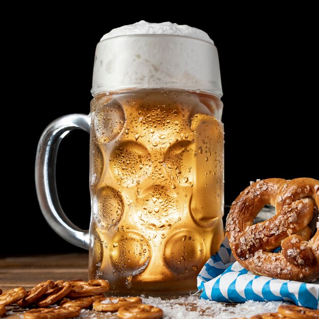 Close-up beer mug with foam and pretzels