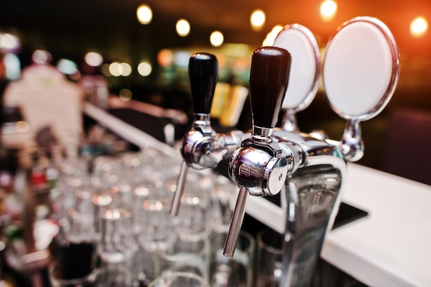 Primo piano delle luci di sfondo del rubinetto della birra al pub