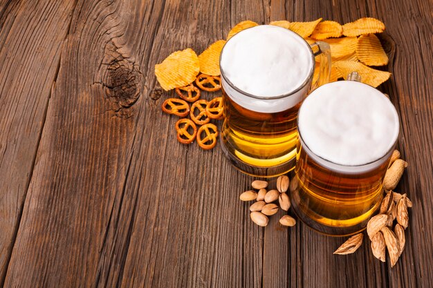 Close-up beer with snacks on wooden table