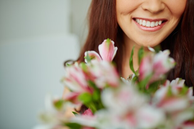 Close-up of a big smile with blurred bouquet