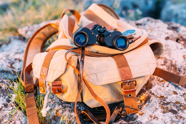 Free photo close-up of binocular and bag on rock