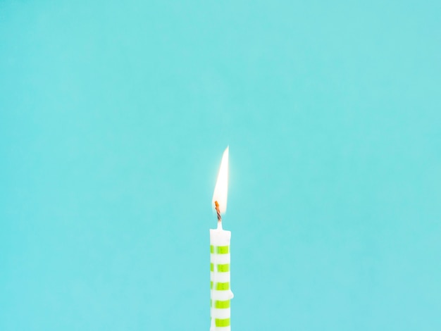 Close-up birthday candle on blue background
