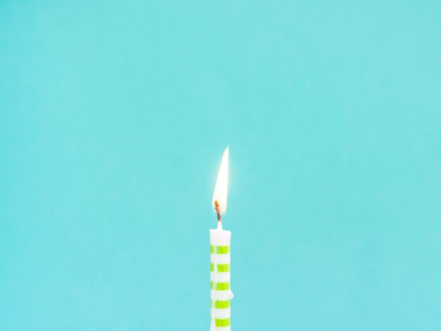 Close-up birthday candle on blue background