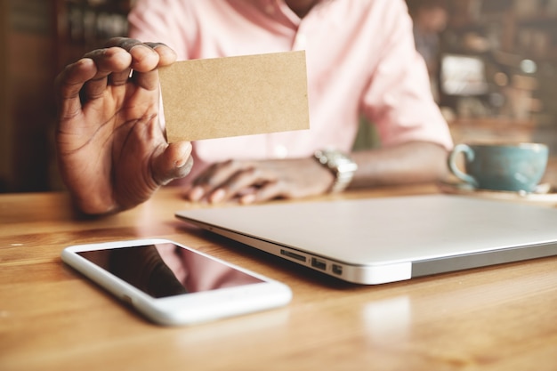 Close up of black male hands holding blank parchment business card