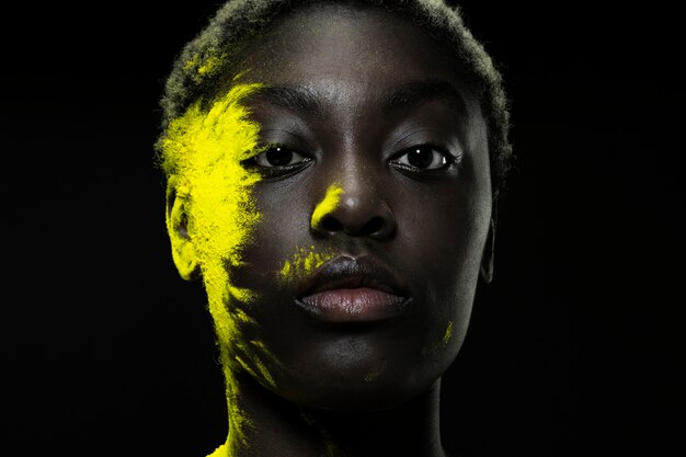 Close up black model with yellow powder