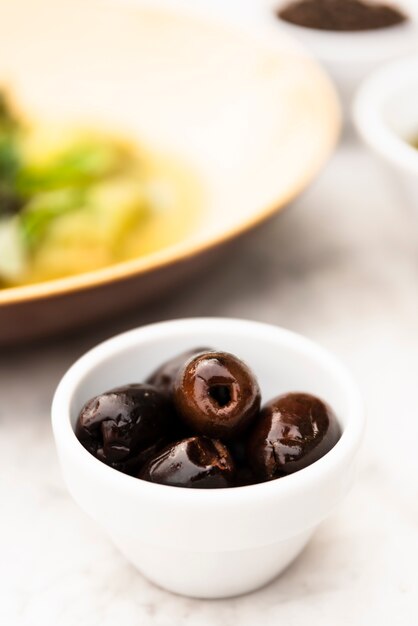 Close-up of black olives in small white bowl