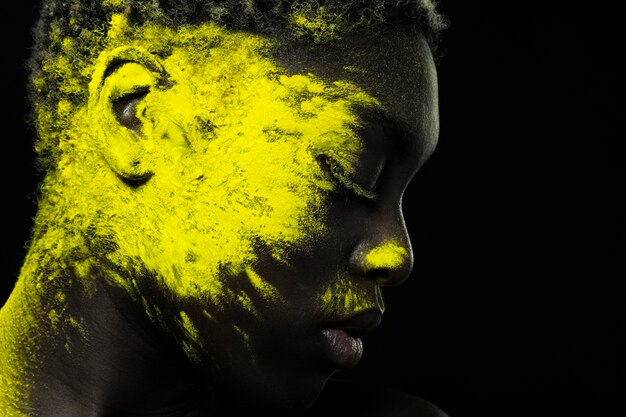 Close up black woman with yellow powder