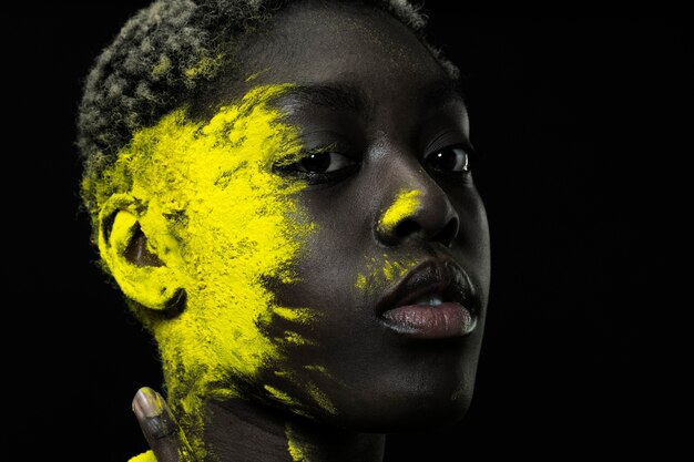 Close up black woman with yellow powder