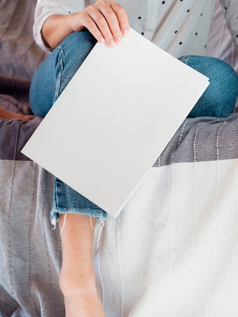 Foto gratuita rivista in bianco del primo piano tenuta da una donna