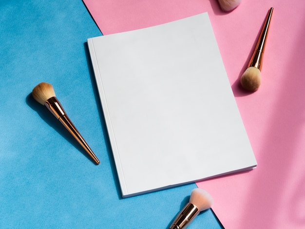 Close-up blank magazine with makeup brushes