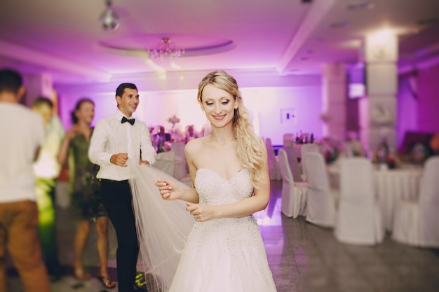 Close-up of blonde bride dancing in the restaurant