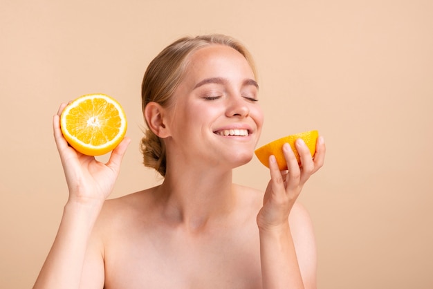 柑橘類と桃の背景を持つクローズアップブロンドの女の子