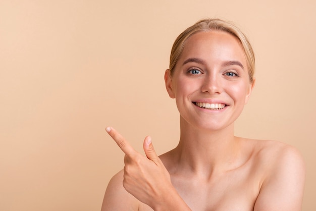 Free photo close-up blonde model pointing at something