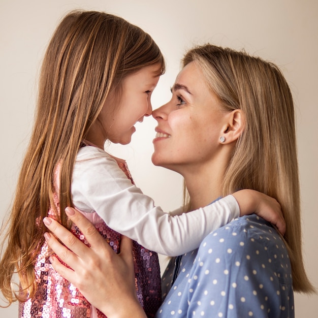 Foto gratuita madre bionda del primo piano che tiene figlia sveglia