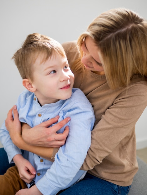 Madre bionda del primo piano che tiene il suo giovane ragazzo