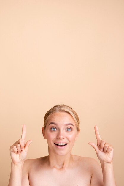 Close-up blonde smiley woman pointing up