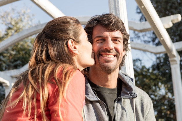 Close-up of blonde woman kissing her smiling husband