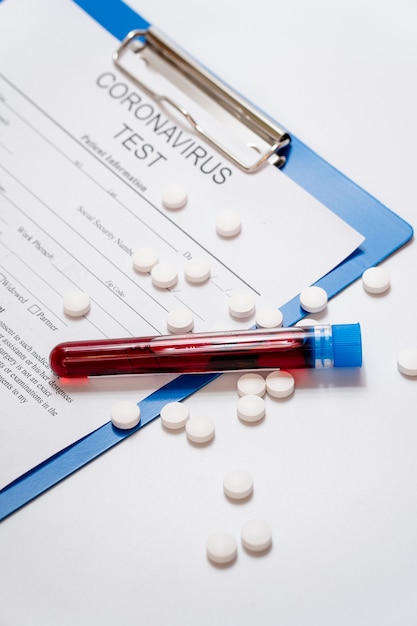 Close-up blood samples with pills and medical form