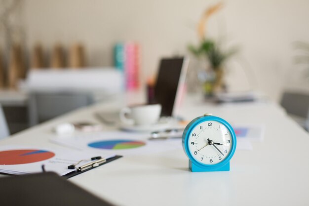 Close up blue alarm clock on desk in modern office