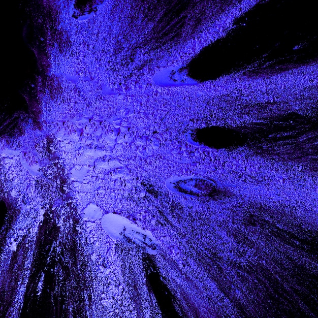 Close-up of blue holi color on dark surface