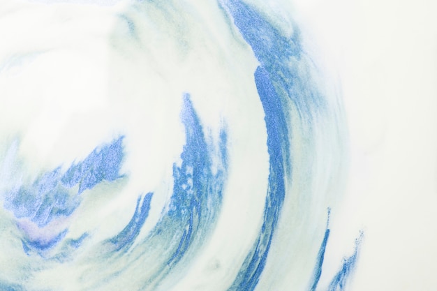 Free photo close-up of blue watercolor strokes over white foam background