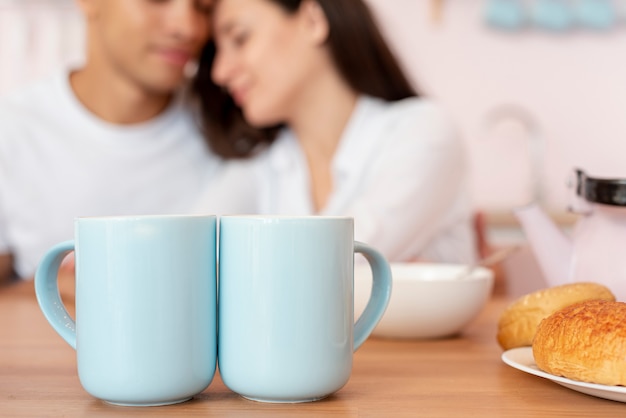 Close-up blurred couple with blue mugs