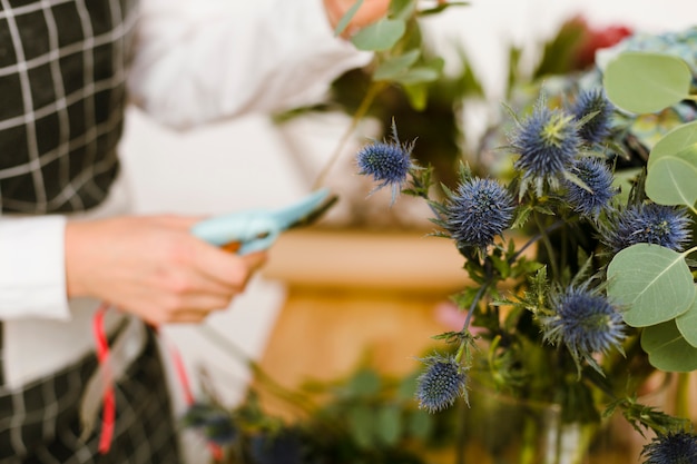 Close-up blurred florist cutting flowers for bouquet