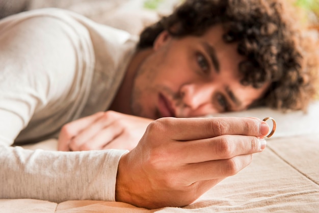 Free photo close-up blurred man holding wedding ring