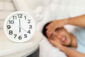 Free photo close-up blurred sleepy guy with clock