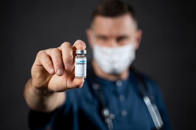 Close up blurry doctor holding vial