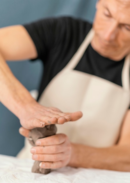 Close-up blurry man holding clay