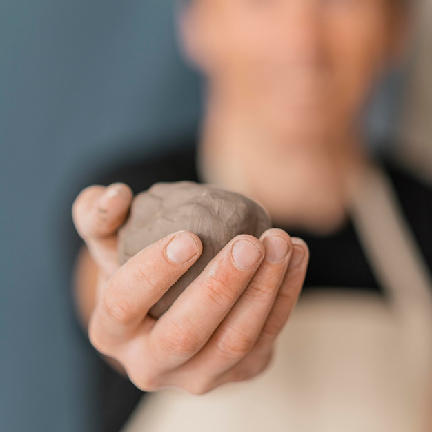 Close-up blurry man holding clay