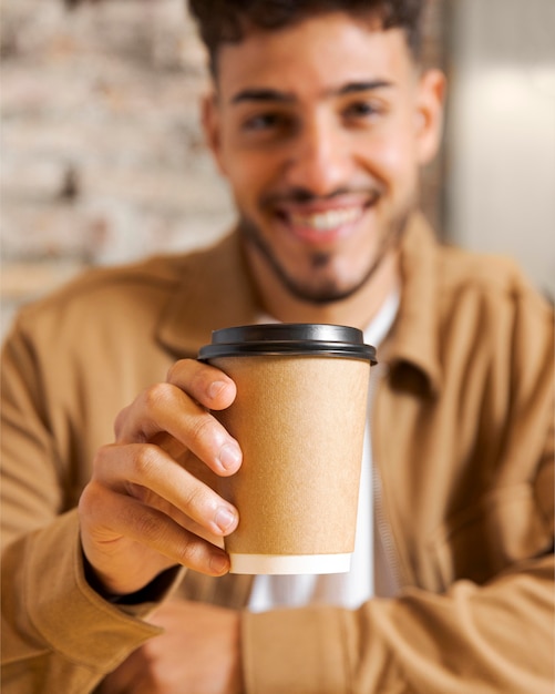 Close up blurry man holding cup