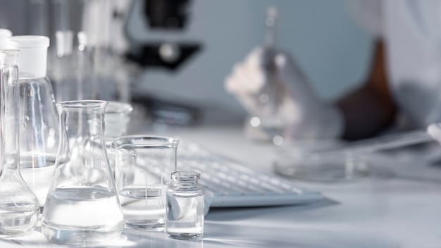 Close-up blurry researcher holding glassware