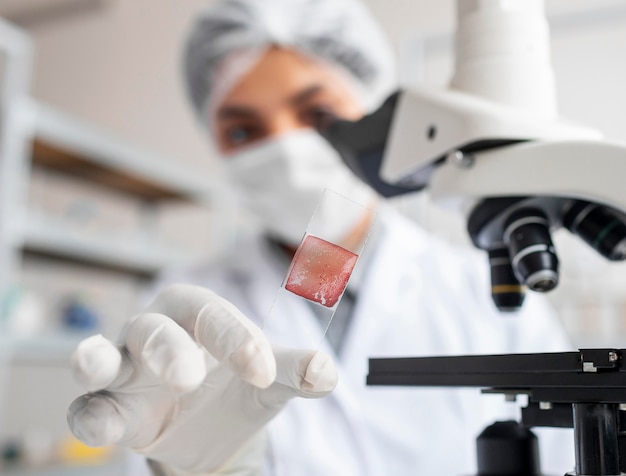 Close up blurry scientist holding glass slide