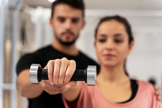 Close up blurry woman exercising with dumbbell