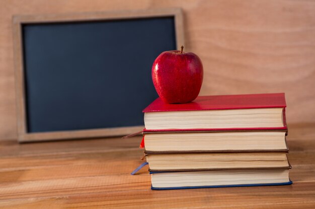 Close-up of books stack with red apple