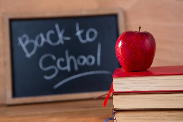 Close-up of books stack with red apple