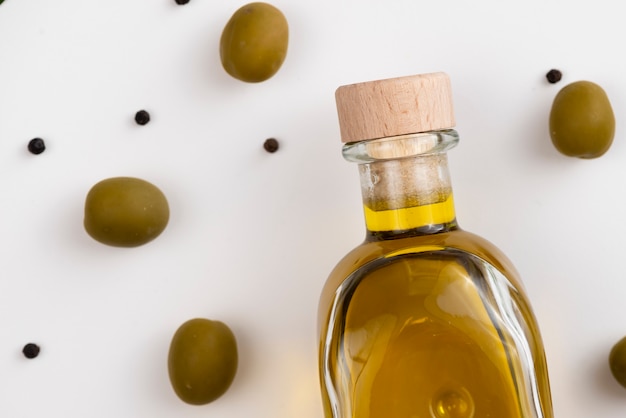 Foto gratuita close-up bottiglia di olio e olive verdi
