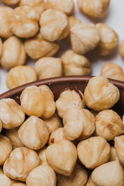 Close-up bowl near spilled hazelnuts