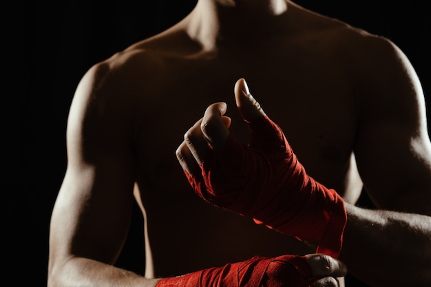 Close up boxer bandaging hands