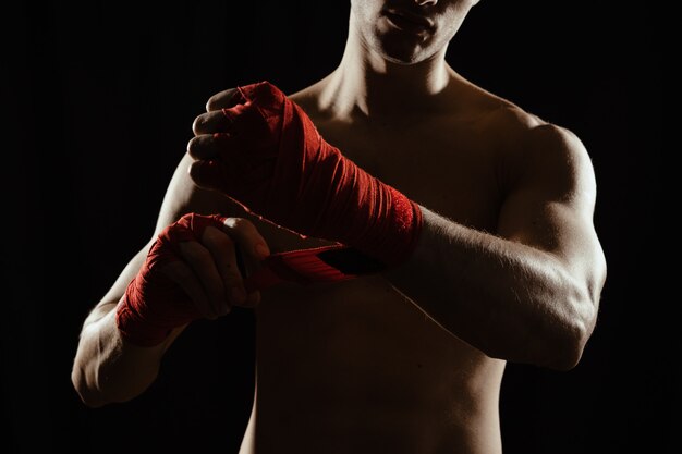 Close up boxer bandaging hands