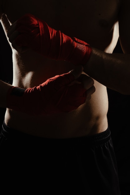 Close up boxer bandaging hands