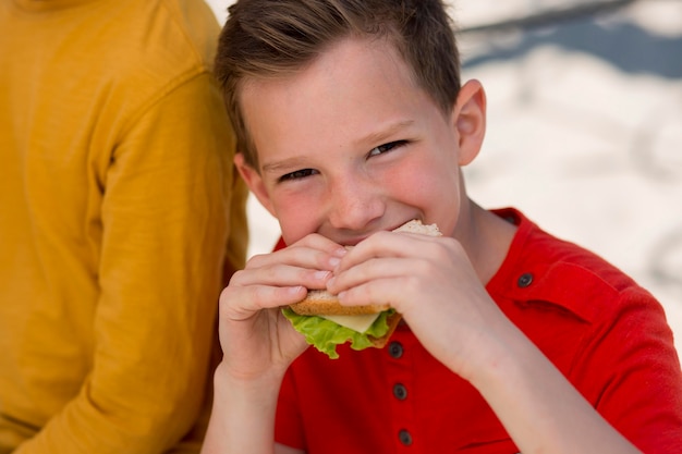 Free photo close up boy eating sandwich