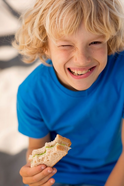 Free photo close up boy eating sandwich