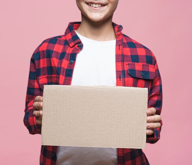 Close-up boy holding blank cardboard