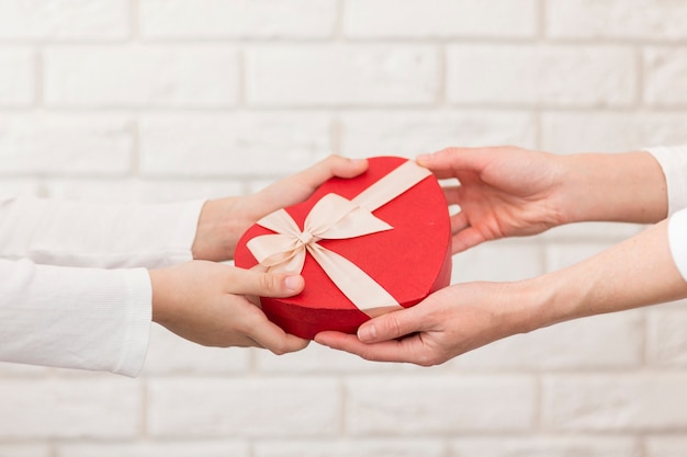 Close-up boy offering chocolate box to mother