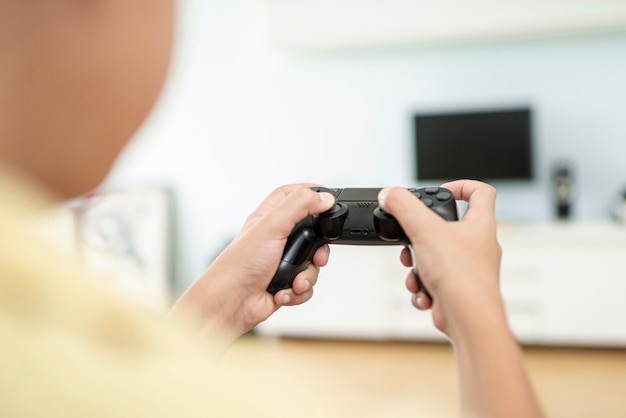 Close-up boy playing with a controller